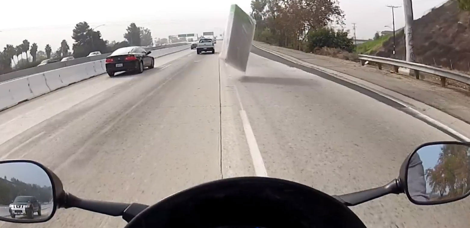 Motorcycle Almost Hits Flying Mattress on Highway